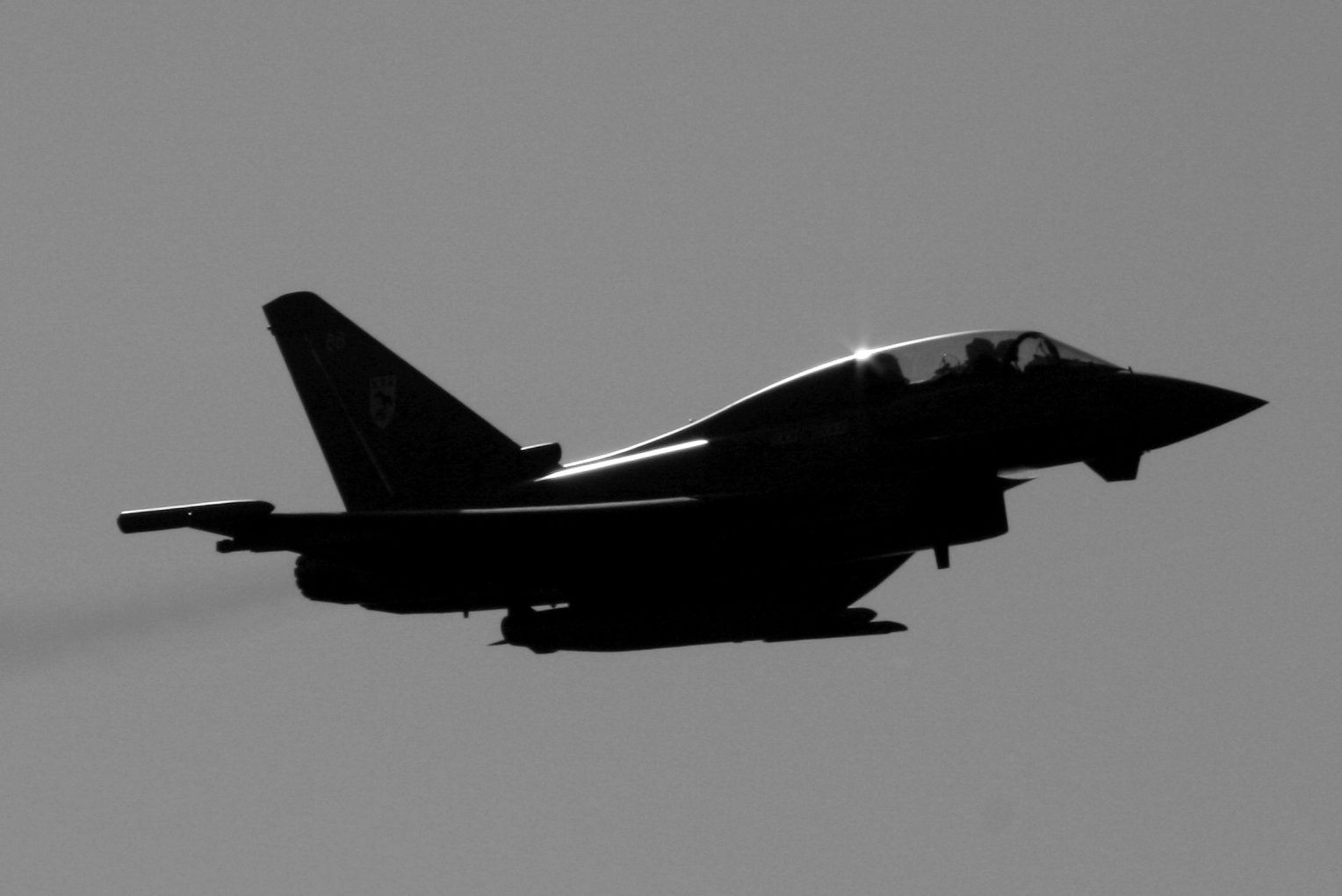 Fighter jet flying through cloudy sky