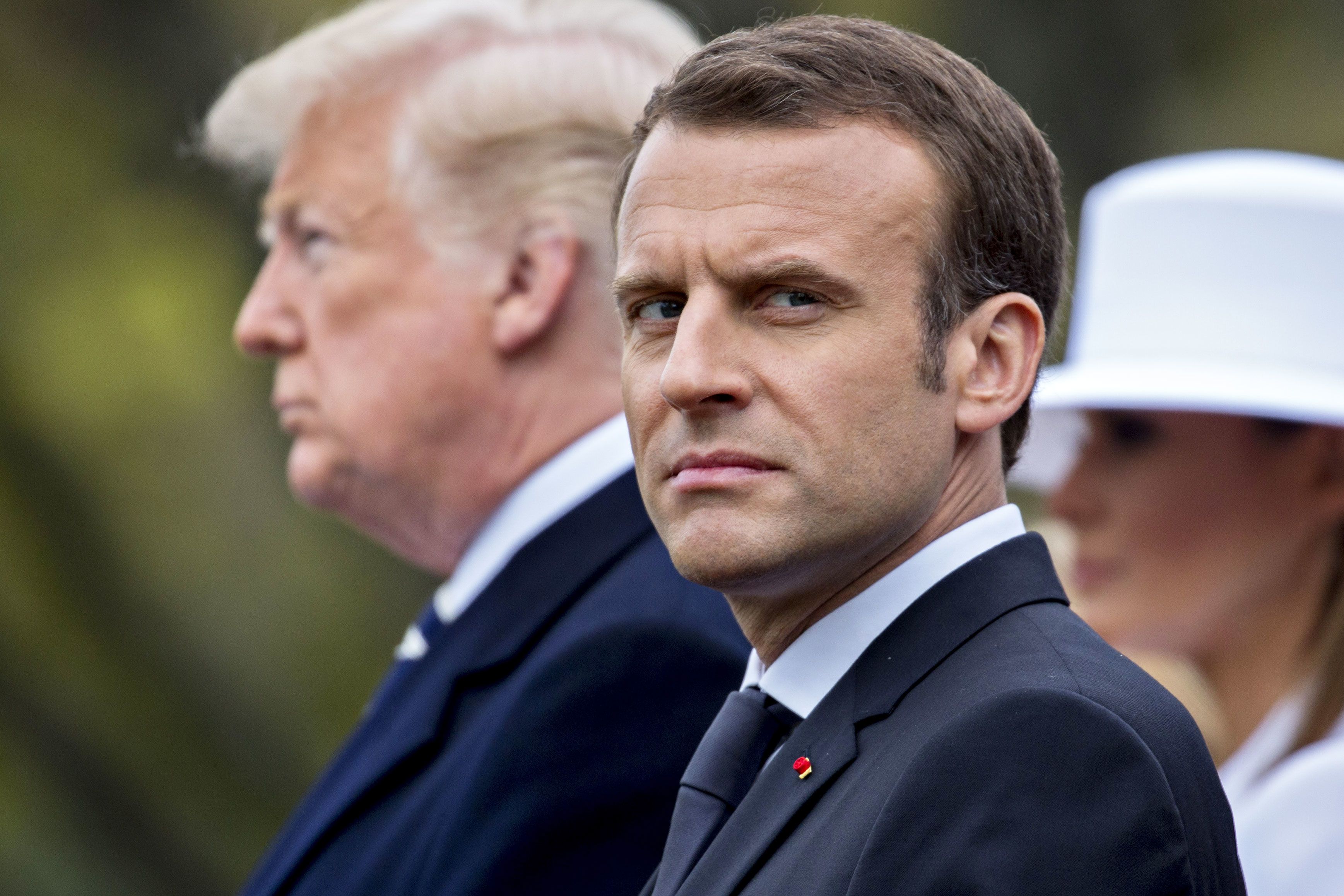 French president Emmanuel Macron standing in front of US president Donald Trump