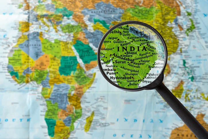 World map with magnifying glass zoomed in on India