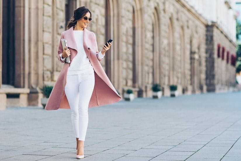 Luxuriously dressed woman walking down a smart street 