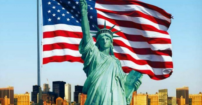 US flag flying behind the Statue of Liberty