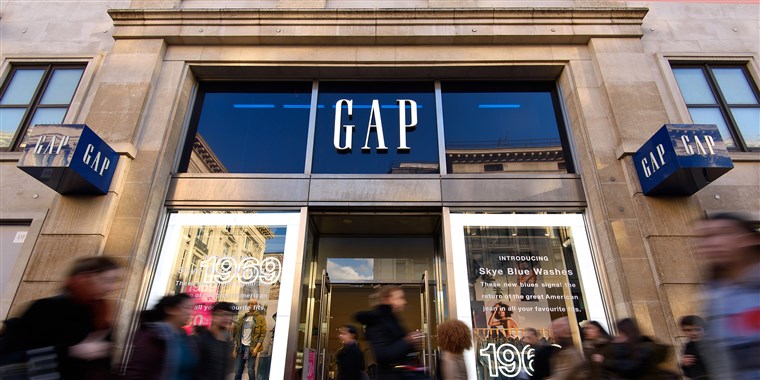 Gap store front on high street with shoppers rushing past 